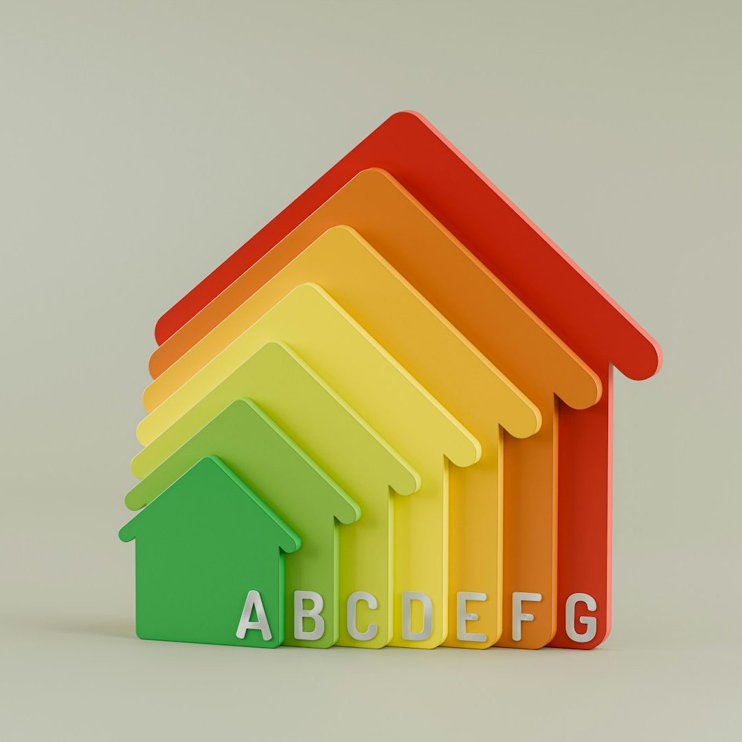 Bunte Haus-Symbole mit Energieeffizienz-Labels von A bis G.